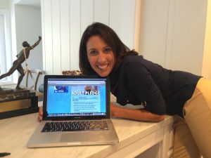 a woman is smiling and holding a laptop computer - Janet Evans takes the Pool Safely Pledge